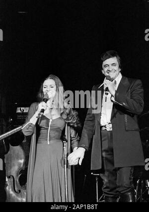 Johnny Cash, amerikanischer Country Sänger und Songschreiber, bei einem Konzert in Hamburg mit Ehefrau June Carter Cash, Deutschland um 1981. American Country Sänger und Songschreiber Johnny Cash und seiner Frau June Carter Cash in Hamburg, Deutschland, um 1981. Stockfoto