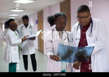 Medizinische Studenten, Praktikanten. Junge Ärzte, gemischten Rennen, auf dem Flur des Krankenhauses, Beratung. X-ray Bilder von Patienten untersucht, medizinische Pr Stockfoto