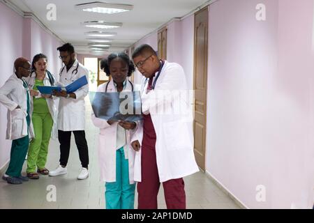 Medizinische Studenten, Praktikanten. Junge Ärzte, gemischten Rennen, auf dem Flur des Krankenhauses, Beratung. X-ray Bilder von Patienten untersucht, medizinische Pr Stockfoto