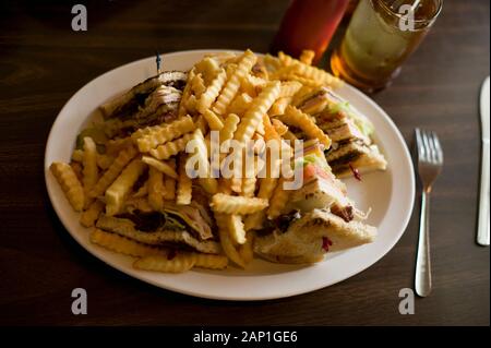 Mast hi-Kalorie Club Sandwich mit Pommes zu einem Diner Tabelle Stockfoto