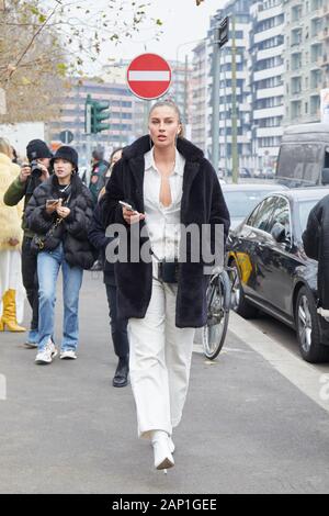 Mailand, Italien - 14 Januar, 2019: Frau mit schwarzen Pelzmantel und weißes Hemd und Hose vor Gucci fashion show, Mailand Fashion Week street style Stockfoto