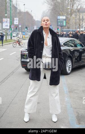 Mailand, Italien - 14 Januar, 2019: Frau mit schwarzen Pelzmantel und weißes Hemd und Hose vor Gucci fashion show, Mailand Fashion Week street style Stockfoto