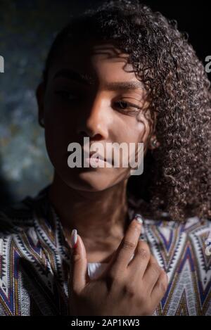 Kunst Portrait eines lateinamerikanischen Mädchen. Schöne mexikanische Frau, auf abstrakte dunklen Hintergrund. Künstlerische dramatischen Licht. Makellose Haut Stockfoto