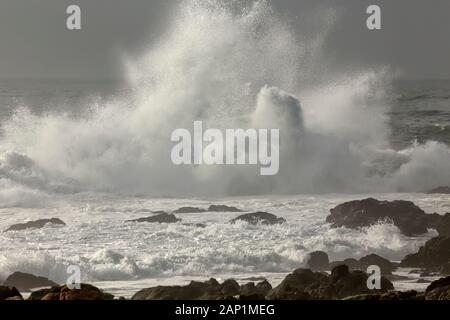 Wave splash in einem felsigen Strand im Norden von Portugal. Stockfoto