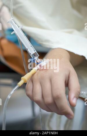 Intravenöse Injektion auf das Kind. Die Hand eines Kindes mit einer Nadel. Intravenöse Infusion System. Kranke Kinder im Krankenhaus. Stockfoto