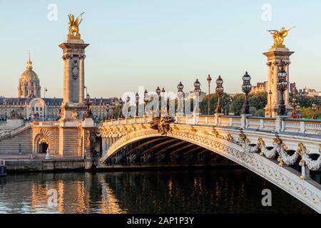 Goldenes Sonnenlicht bei Dämmerung über Seine, Pont Alexandre III und Hotel des Invalides, Paris, Ile-de-France, Frankreich Stockfoto