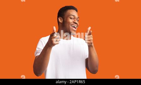 Happy afro Kerl, den Sie wählen über orange Hintergrund Stockfoto