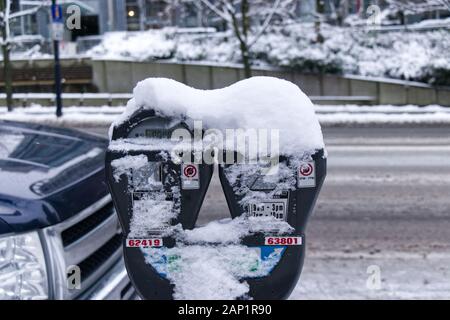 Vancouver, Kanada - 13. Januar 2020: Parkmesser an der West Georgia Street im Schnee bedeckt. Schneesturm und extremes Wetter in Vancouver. Stockfoto
