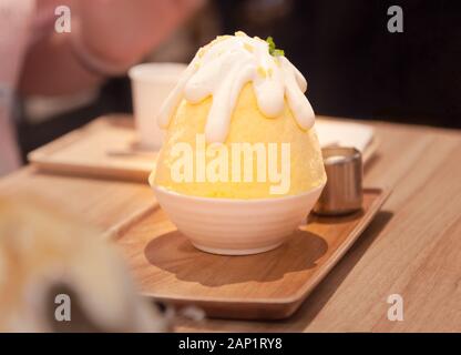 Koreanische rasiert Eis oder Schnee Kegel (bingsu, bingsoo) Dessert mit gehackten frischen tropischen Mangofrucht, Kondensmilch, Fruchtsirup süßen Toppings. Traditio Stockfoto