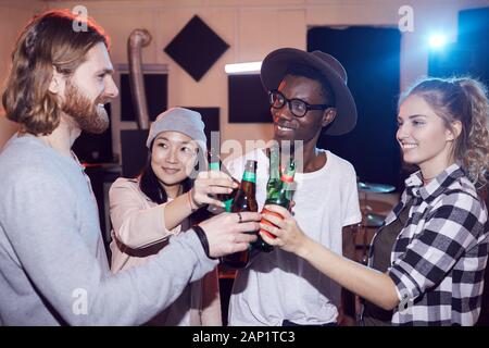 Multi-ethnischen Gruppe junger Leute Bier trinken und plaudern, während Sie Probe im Music Studio, Schuß mit Flash Stockfoto
