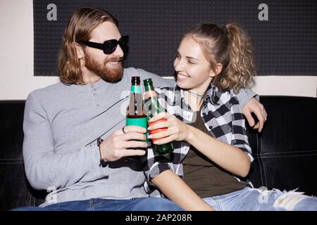 Portrait des modernen junges paar Bierflaschen klirren beim Genießen Disco Party, geschossen mit Flash Stockfoto