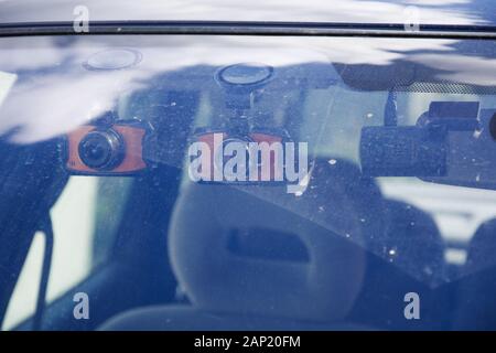 Drei Armaturenbrettkameras, die an der verschmutzten Frontscheibe montiert sind. Kamera DVR Dash Cam für die Sicherheit bei Verkehrsunfällen. Blick von außerhalb des Autos. Stockfoto