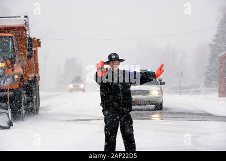 Ein Blizzard auf Landstraße führt zu einer lokalen Polizisten Verkehr zu stoppen Stockfoto