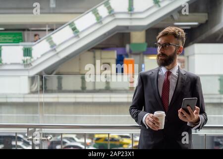 Die Jungen gut aussehenden bärtigen Persischen Geschäftsmann entspannende rund um die Stadt Stockfoto