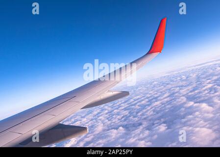 Himmel durch das Flugzeugfenster, Sonnenaufgang über Wolken Stockfoto