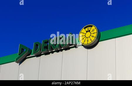 Dinslaken, Deutschland - Dezember 18. 2019: Grünes Logo und Schriftzug der deutschen Wirtschaftsprüfungsgesellschaft Dekra gegen wolkenlosen blauen Himmel am Dach des Gebäudes Stockfoto