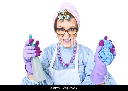 Portrait der glücklichen alten Putzfrau in Schürze mit Staub Reinigungsbürste auf blauem Hintergrund isoliert. Spezielle einheitliche und professionelle Ausrüstung für Stockfoto