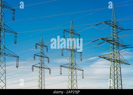 Oben auf Hochspannungsmasten vor einem Blauen, bewölkter Himmel. Stockfoto