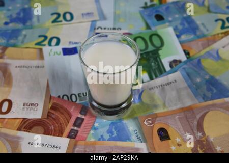 Milch Preis und landwirtschaftliche Produkte trend Konzept: kleines Glas Milch auf Euro Banknoten Stockfoto