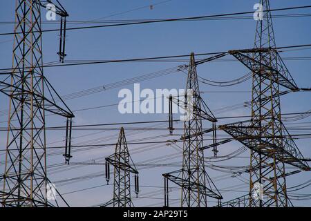 Oben auf Hochspannungsmasten vor einem Blauen, Abendhimmel. Stockfoto