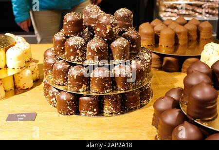 Nahaufnahme von isolierten stack Creme braun Chocolate kisses mit bunten Süßigkeiten gefüllt besprüht Stockfoto