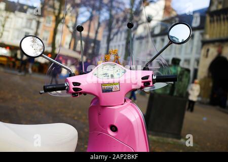 Maastricht, Niederlande - 30 November. 2019: Blick über den Lenker, Drehzahlmesser, der Windschutzscheibe und Außenspiegel des Retro rosa Vespa Roller auf verschwommen Stockfoto