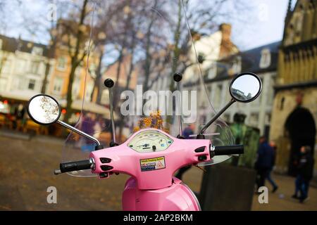 Maastricht, Niederlande - 30 November. 2019: Blick über den Lenker, Drehzahlmesser, der Windschutzscheibe und Außenspiegel des Retro rosa Vespa Roller auf verschwommen Stockfoto