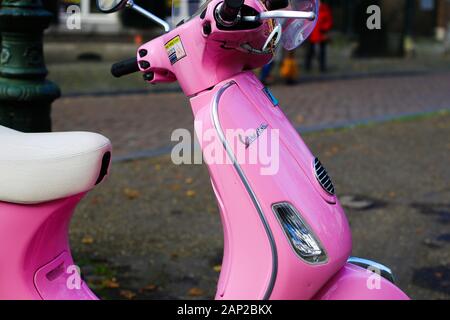 Maastricht, Niederlande - 30 November. 2019: Seitenansicht auf Retro rosa Vespa Roller auf Platz der Stadt geparkt Stockfoto