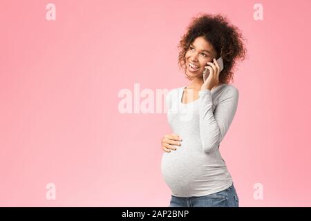 Afro schwangere Frau Gespräch am Handy mit seinem Arzt Stockfoto