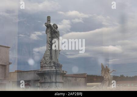 Statuen, die auf einem Glas auf einem Friedhof reflektiert wurden Stockfoto