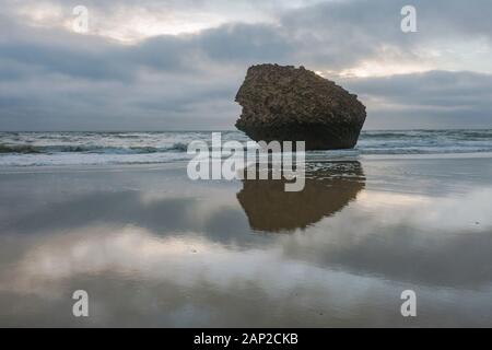 Der Felsen, Teil eines alten, auf dem Kopf stehenden Turms (Torre de la Higuera) am Strand in Matalascañas, Huelva, Spanien. Stockfoto