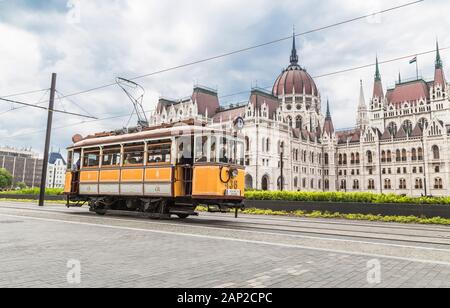 BUDAPEST, Ungarn - 03.Mai 2014: Gelb vintage Straßenbahn auf den Straßen der Stadt auf dem Hintergrund der Parlamentsgebäude. Budapest. Ungarn Stockfoto