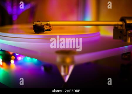 Der tonarm von isolierten Vintage Retro Plattenspieler mit weißem Vinyl Lp. Glänzend bunten bokeh Hintergrund. Stockfoto