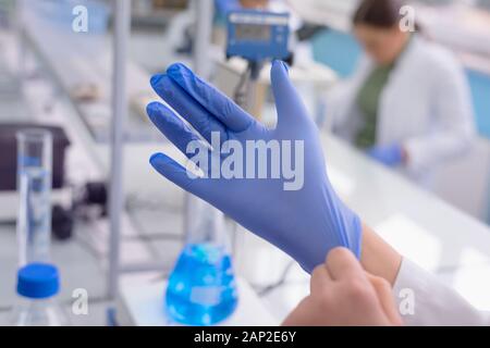 Junge weibliche Labor Wissenschaftler tragen Handschuhe für die Arbeit im Labor mit Reagenzgläsern, Test oder Forschung im klinischen Labor. Wissenschaft, Chemie, biol Stockfoto