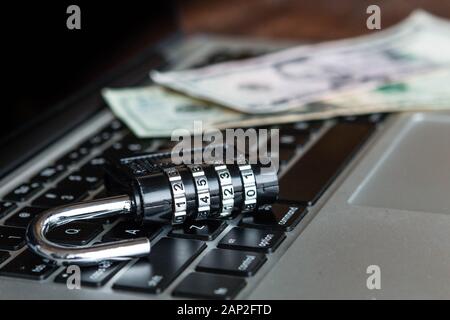 Vorhängeschloss und Geld auf einem Laptop. Online Security Konzept, Online-Banking, Anti Virus Stockfoto