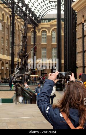 Weibliche Touristen fotografieren mit Smartphone in der Hay's Galleria an der South Bank, London, Großbritannien Stockfoto