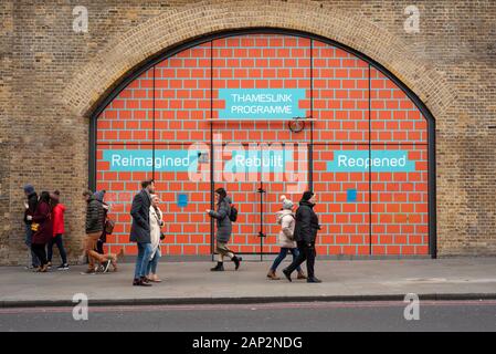 Londoner Infrastruktur Menschen, die an Wandgemälden vorbeilaufen, die das Thameslink-Programm an der London Bridge Station in Duke St Hill, London, UK AS 2020, bewerben Stockfoto