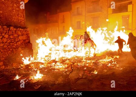 Vilanova d'Alcolea, Castellón, Spanien - 19. Januar 2019: Menschen und ein Mann, der mit seinem Pferd reitet, springen beim traditionellen Festival über Lagerfeuer Stockfoto