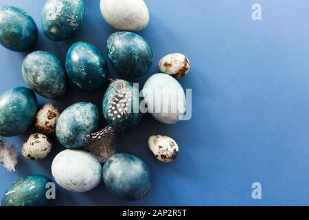 Schöne Gruppe ombre blau Ostereier mit wachtel Eier und Federn auf blauem Hintergrund. Ostern Konzept Stockfoto