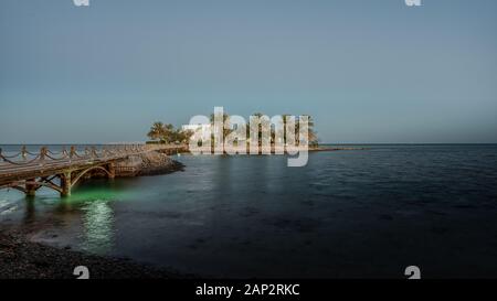 Weiße Villa auf einer kleinen Insel mit Palmen und eine Brücke, die in der Dämmerung Abend licht, El Guna, Ägypten, Januar 07, 2020 Stockfoto