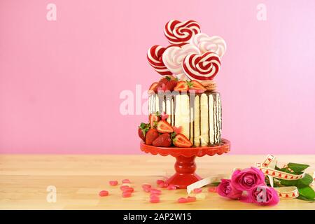 Valentinstag auf - Tendenz candyland Fantasy drip Neuheit Kuchen mit herzförmige Lollis, Candy und frische Erdbeeren dekoriert, mit negativen Cop Stockfoto