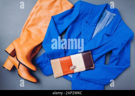 Classic blau trendige Farbe von 2020. Feder weibliche Kleidung Outfit. Stilvolle blaue Jacke, braune Schuhe Stiefel, Geldbörse Stockfoto