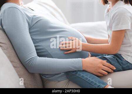 Der Vorschule Mädchen sitzen auf schwangere Mama Runde 7/8 Stockfoto