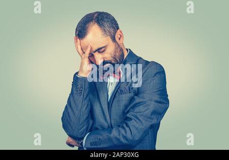 Closeup Portrait traurig Reife stattlicher Mann mit Sorgen, betonte Gesichtsausdruck. Gemischte Rasse bearded Modell auf grün gelb Studio isoliert Stockfoto