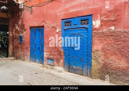 Passage in Medina mit orangefarbenen Wänden und blauen Türen Stockfoto