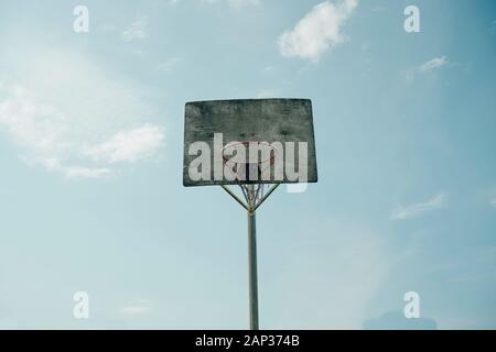 Von unten Alte unbemalt Basketball Backboard und Hoop mit Net unter blauem Himmel Stockfoto