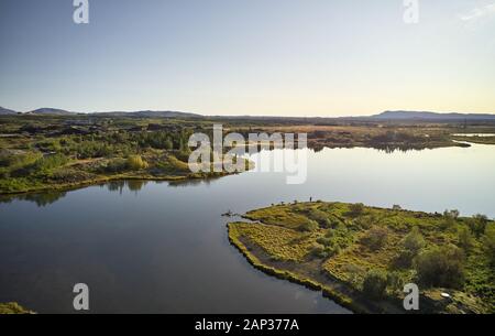 Von oben erstaunliche Landschaft von gewundenen Fluss Küste mit grünen Büsche und Bäume gegen den Hügel am Horizont unter klaren Himmel Stockfoto