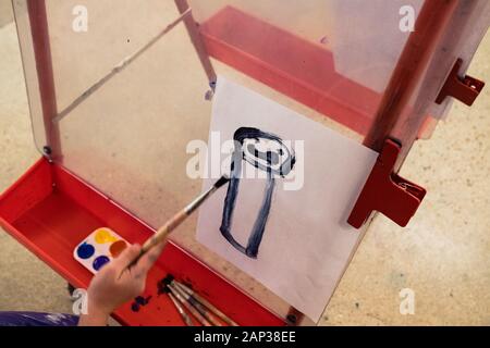 Kind malt ein Porträt einer Person in einem Kunststudio Stockfoto