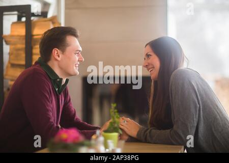 Junges Paar in einem Wohnzimmer mit Händen Stockfoto