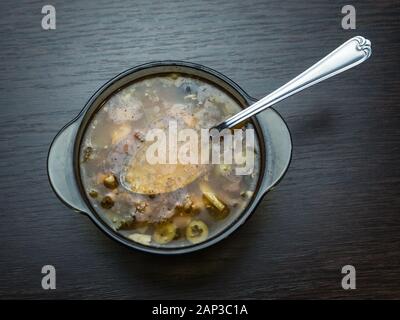 Solyanka in eine Glasplatte mit einem eisernen Löffel Stockfoto